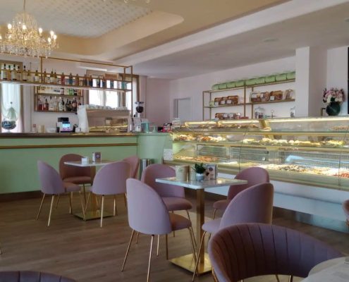Sala completa della Pasticceria Fabirica arredata su misura con tavoli e sedie di design sulle tonalità del rosa e verde chiaro.