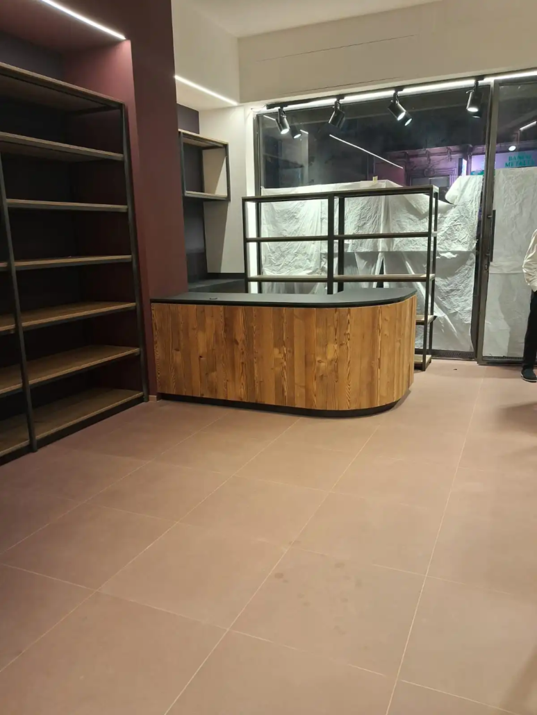 arredamento-vineria-su-misura-lavorazione-bancone Bancone su misura in legno scuro con angolo curvo in lavorazione per l'arredamento di una vineria.